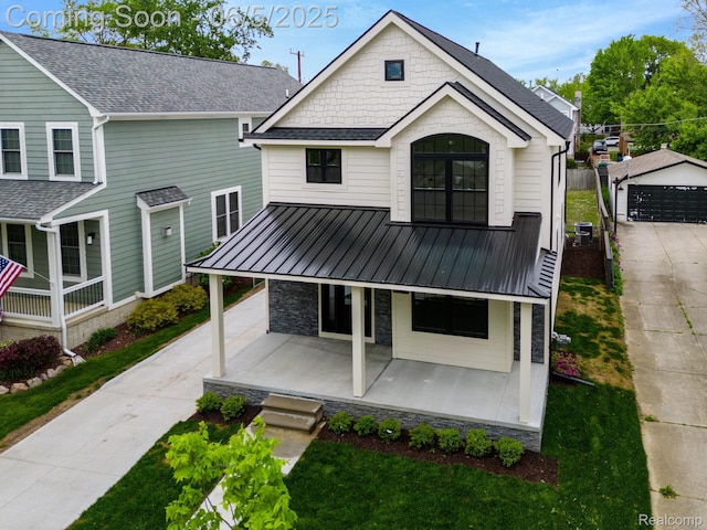 1285 Ruffner Ave, Birmingham, MI 48009 - view of front of home featuring a porch, stone siding, a front lawn, an outbuilding, and metal roof