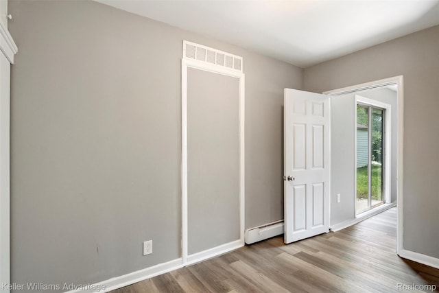 26315 Lehner St, Roseville, MI 48066 - unfurnished bedroom with wood finished floors, a baseboard heating unit, and baseboards