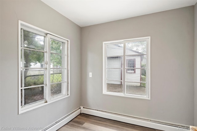 26315 Lehner St, Roseville, MI 48066 - unfurnished room with a baseboard heating unit, plenty of natural light, wood finished floors, and baseboards