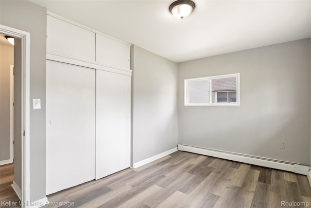 26315 Lehner St, Roseville, MI 48066 - unfurnished bedroom with wood finished floors, a baseboard heating unit, a closet, and baseboards