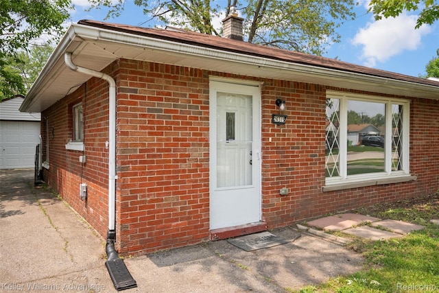 26315 Lehner St, Roseville, MI 48066 - property entrance with brick siding, a chimney, and a garage