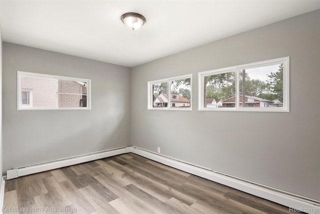 26315 Lehner St, Roseville, MI 48066 - spare room featuring wood finished floors, a baseboard radiator, and a baseboard heating unit