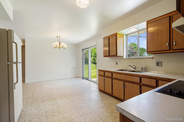 1312 N Bielby St, Waterford, MI 48328 - kitchen with freestanding refrigerator, a sink, a chandelier, light countertops, and tasteful backsplash