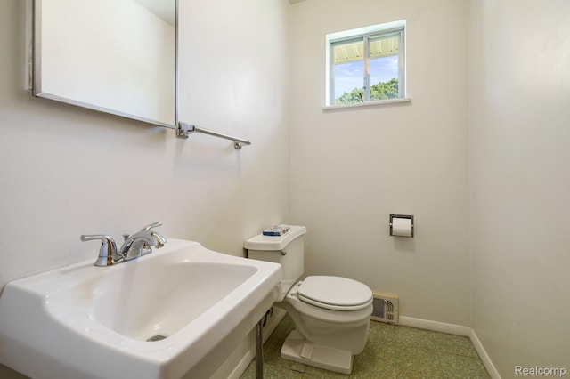 1312 N Bielby St, Waterford, MI 48328 - bathroom featuring toilet, a sink, and baseboards