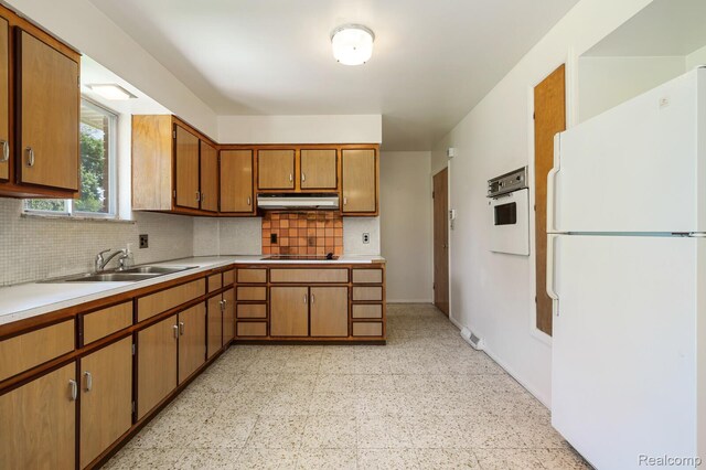 1312 N Bielby St, Waterford, MI 48328 - kitchen with white appliances, a sink, under cabinet range hood, decorative backsplash, and light countertops