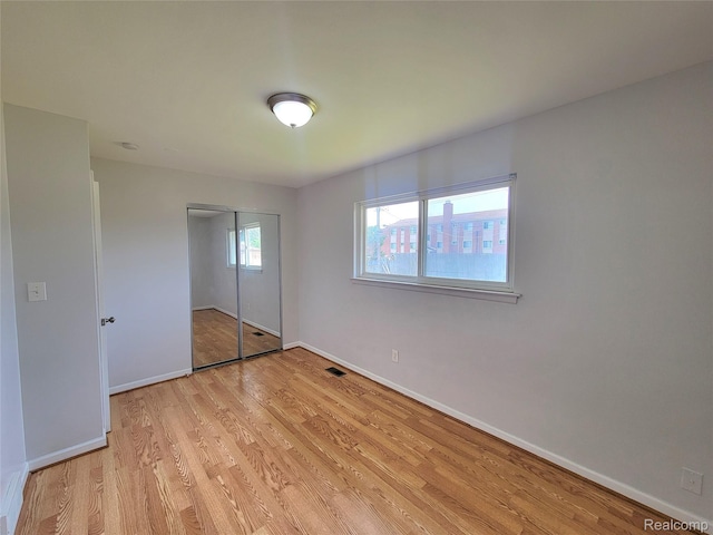 11618 Highland Dr, Warren, MI 48089 - unfurnished bedroom with light wood finished floors, baseboards, and a closet