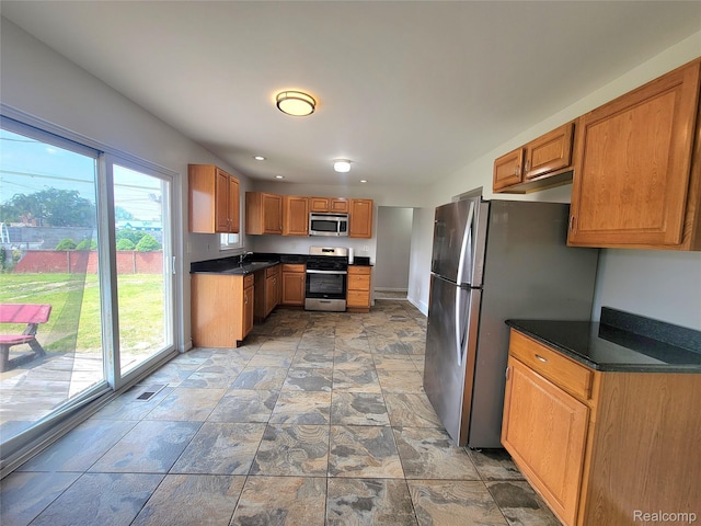 11618 Highland Dr, Warren, MI 48089 - kitchen featuring appliances with stainless steel finishes, plenty of natural light, a sink, and dark countertops