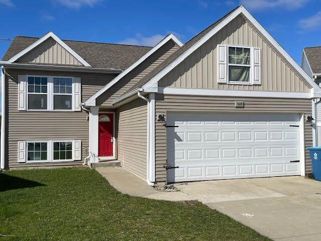 1329 Ellery Grove Ct, Vicksburg, MI 49097 - view of front of house featuring board and batten siding, concrete driveway, and a front yard