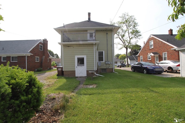624 Waterloo Ave, Monroe, MI 48161 - rear view of house featuring a balcony, a lawn, and a chimney