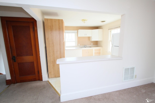 624 Waterloo Ave, Monroe, MI 48161 - kitchen featuring freestanding refrigerator, light colored carpet, healthy amount of natural light, and a peninsula