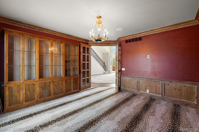 2921 Turtle Pond Ct, Bloomfield Hills, MI 48302 - spare room featuring carpet, stairway, a chandelier, ornamental molding, and wainscoting