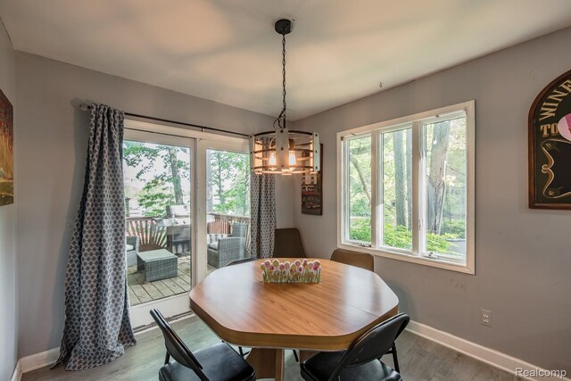 2475 S Ortonville Rd S, Ortonville, MI 48462 - dining space featuring healthy amount of natural light, a chandelier, wood finished floors, and baseboards