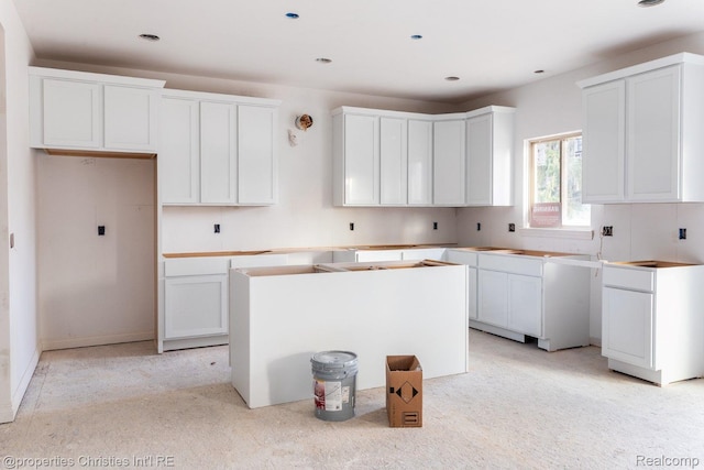 3201 Roma Ct, Wixom, MI 48393 - kitchen featuring a center island, light carpet, white cabinets, and recessed lighting