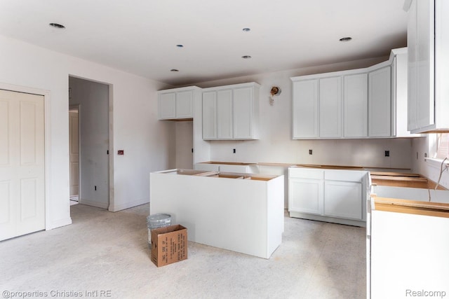 3201 Roma Ct, Wixom, MI 48393 - kitchen featuring a kitchen island and white cabinetry