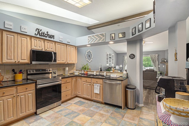 7374 Cross Creek Dr, Swartz Creek, MI 48473 - kitchen featuring appliances with stainless steel finishes, dark countertops, a sink, tasteful backsplash, and open floor plan