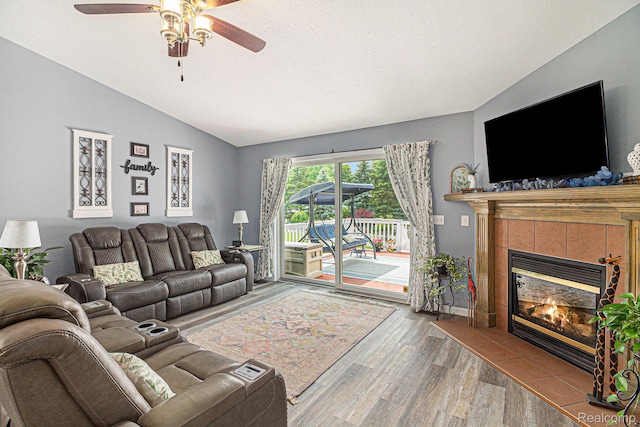 7374 Cross Creek Dr, Swartz Creek, MI 48473 - living area with vaulted ceiling, wood finished floors, a ceiling fan, a fireplace, and a textured ceiling
