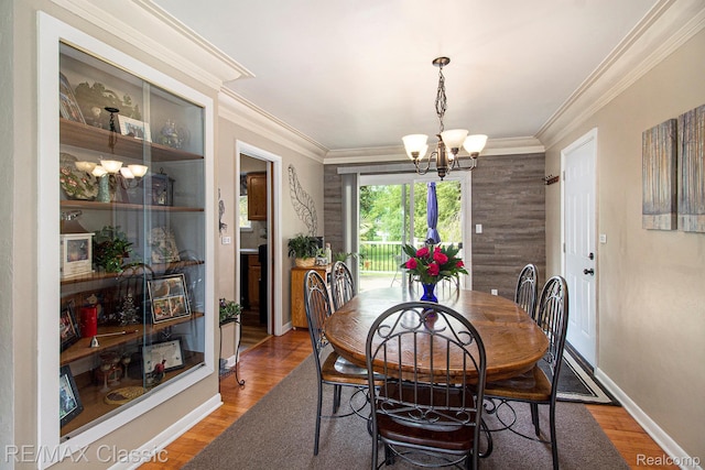 38 Meadowview Dr, Howell, MI 48843 - dining room with a chandelier, wood finished floors, crown molding, and baseboards
