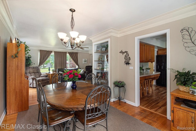 38 Meadowview Dr, Howell, MI 48843 - dining room featuring a chandelier, ornamental molding, wood finished floors, and baseboards