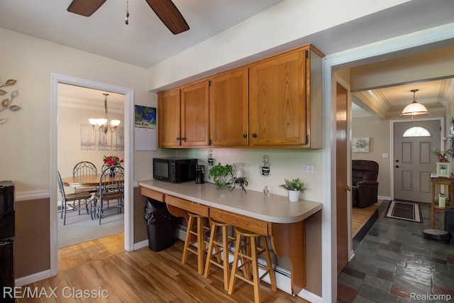 38 Meadowview Dr, Howell, MI 48843 - kitchen featuring black microwave, light countertops, ornamental molding, ceiling fan, and brown cabinetry