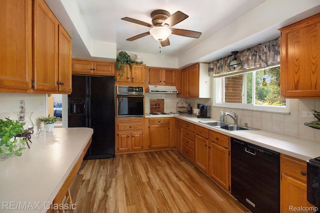 38 Meadowview Dr, Howell, MI 48843 - kitchen featuring black appliances, a sink, extractor fan, light wood-style floors, and light countertops