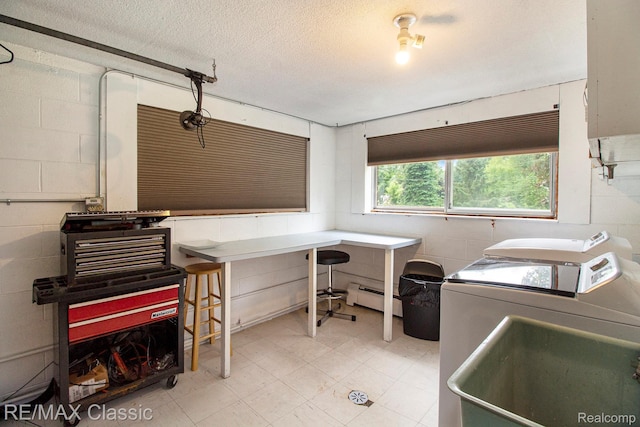 38 Meadowview Dr, Howell, MI 48843 - washroom with baseboard heating, washing machine and clothes dryer, concrete block wall, light flooring, and a textured ceiling