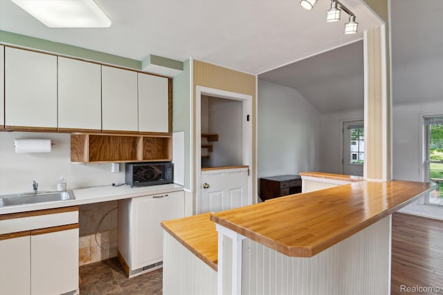 3417 Edgewood Dr, Ann Arbor, MI 48104 - kitchen with butcher block countertops, a sink, black microwave, white cabinetry, and a breakfast bar area