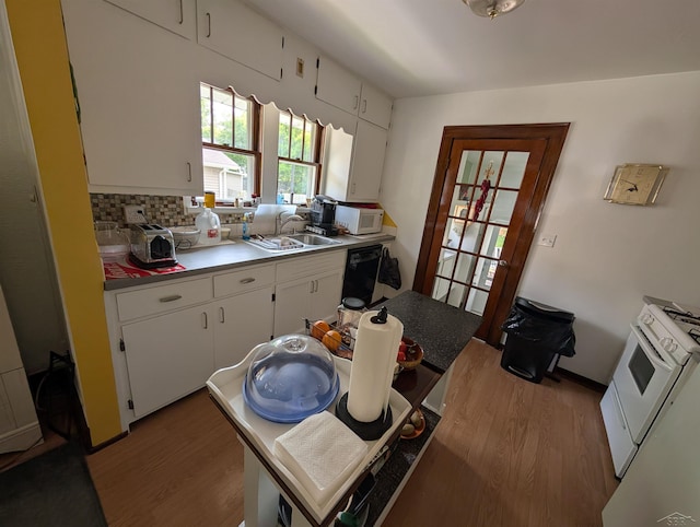 307 Aplin St, Bay City, MI 48706 - kitchen featuring wood finished floors, dishwasher, a sink, and white cabinets