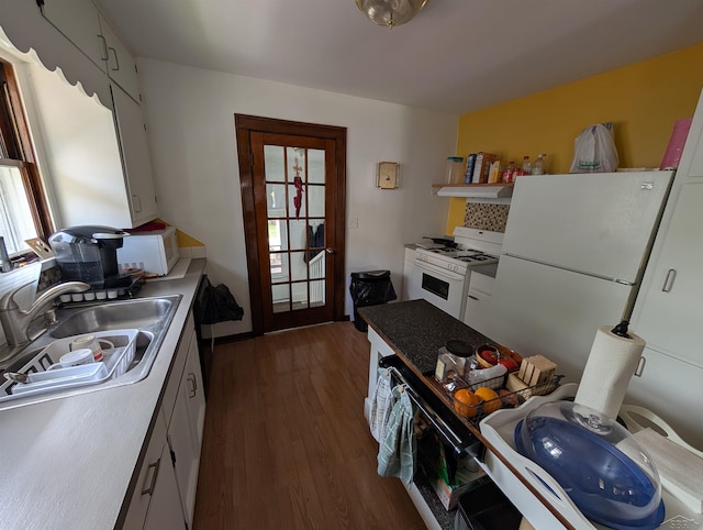 307 Aplin St, Bay City, MI 48706 - kitchen featuring white appliances, plenty of natural light, under cabinet range hood, and dark wood-style floors