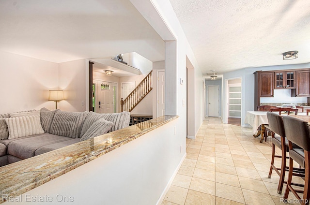 2400 Rolandale, West Bloomfield, MI 48324 - living room with light tile patterned floors, stairs, baseboards, and a textured ceiling
