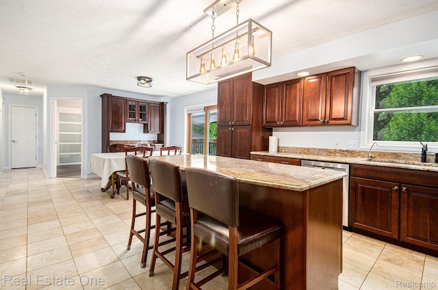 2400 Rolandale, West Bloomfield, MI 48324 - kitchen featuring dishwasher, a sink, a breakfast bar area, light tile patterned floors, and a kitchen island