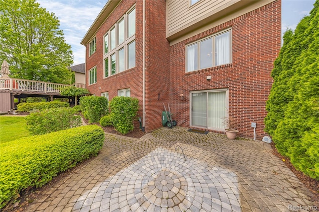 2401 Spyglass Dr, Oakland, MI 48363 - rear view of property featuring a patio, a wooden deck, and brick siding