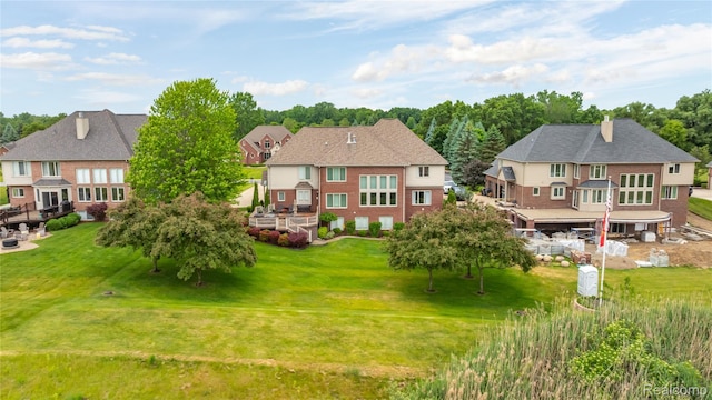 2401 Spyglass Dr, Oakland, MI 48363 - back of house with a yard, brick siding, and a residential view