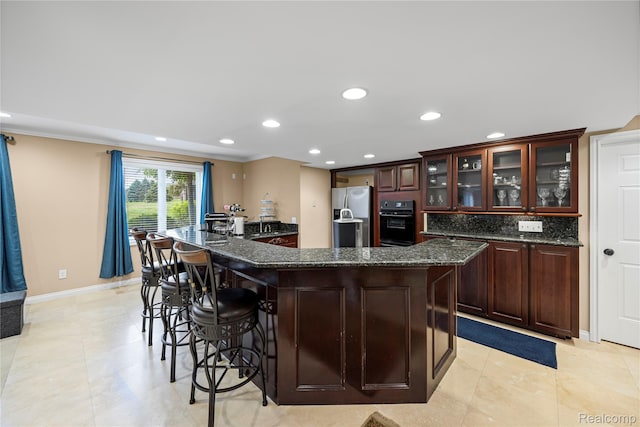 2401 Spyglass Dr, Oakland, MI 48363 - kitchen featuring stainless steel fridge, a kitchen breakfast bar, a large island, recessed lighting, and glass insert cabinets