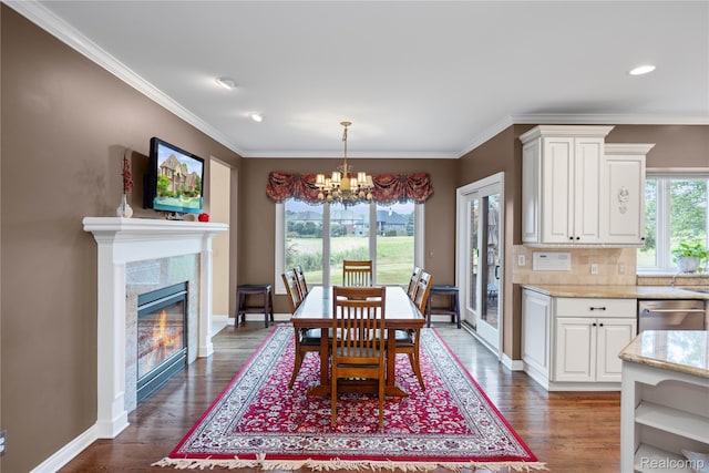 2401 Spyglass Dr, Oakland, MI 48363 - dining area with a chandelier, dark wood finished floors, crown molding, a glass covered fireplace, and recessed lighting