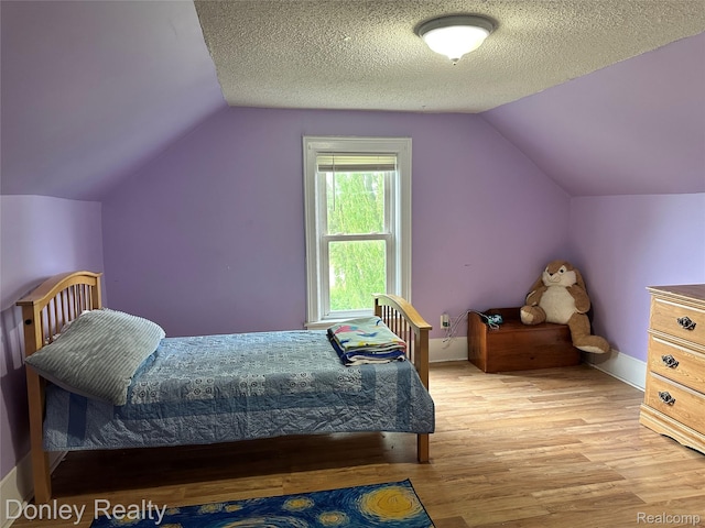 1286 Elmer Rd, Sandusky, MI 48471 - bedroom featuring light wood-style floors, lofted ceiling, baseboards, and a textured ceiling