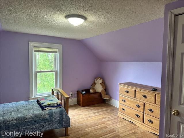 1286 Elmer Rd, Sandusky, MI 48471 - bedroom featuring light wood-type flooring, lofted ceiling, a textured ceiling, and baseboards