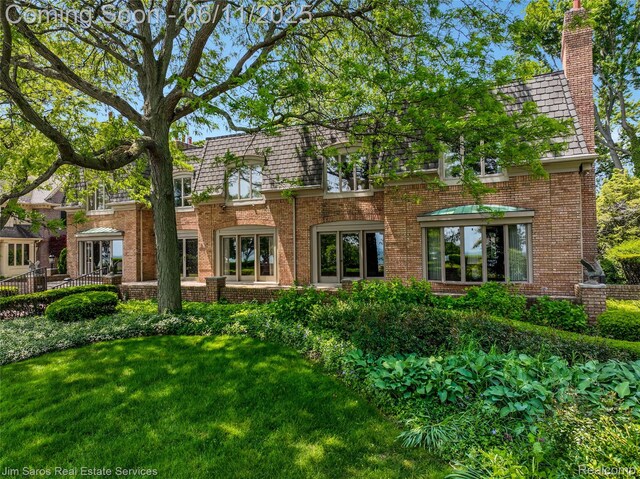 561 Lake Shore Rd, Grosse Pointe Shores, MI 48236 - rear view of property with brick siding, a yard, mansard roof, and a chimney