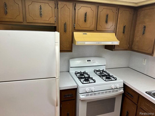 2763 Ranieri Dr, Troy, MI 48085 - kitchen with white appliances, custom exhaust hood, light countertops, and brown cabinets
