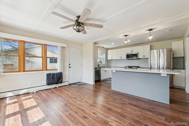 2064 N Long Lake Rd, Fenton, MI 48430 - kitchen with stainless steel appliances, decorative backsplash, light countertops, a kitchen island, and a ceiling fan