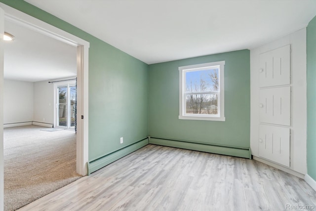 2064 N Long Lake Rd, Fenton, MI 48430 - spare room featuring baseboard heating, wood finished floors, and baseboards