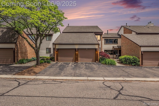 4483 Laurel Club Cir W, Bloomfield, MI 48323 - view of front of house with a garage, a shingled roof, brick siding, and asphalt driveway