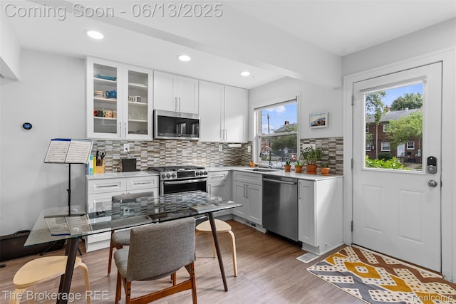 3344 Coolidge Hwy, Royal Oak, MI 48073 - kitchen featuring stainless steel appliances, wood finished floors, backsplash, light countertops, and glass insert cabinets