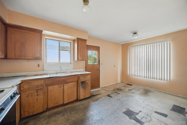 13332 Masonic Blvd, Warren, MI 48088 - kitchen featuring a sink, stove, brown cabinetry, and light countertops