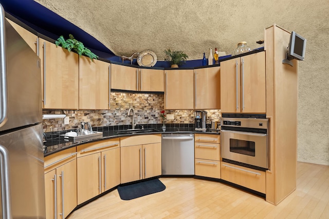 2755 N 9th St, Kalamazoo, MI 49009 - kitchen featuring appliances with stainless steel finishes, a sink, light brown cabinets, dark countertops, and backsplash