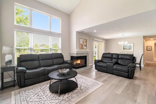 1599 Weatherstone Dr Unit 245, Ann Arbor, MI 48108 - living room with a chandelier, light wood finished floors, a premium fireplace, healthy amount of natural light, and a high ceiling