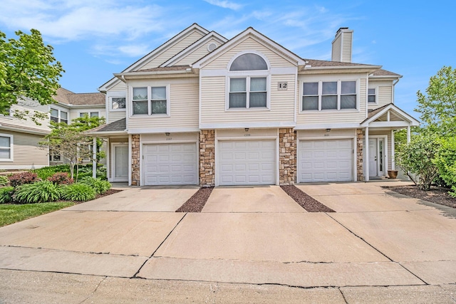1599 Weatherstone Dr Unit 245, Ann Arbor, MI 48108 - multi unit property with stone siding, driveway, a chimney, and an attached garage