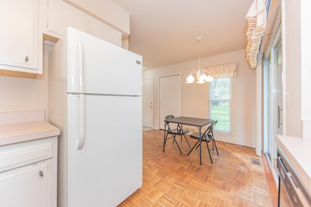 2705 Winthrop Ct, Ann Arbor, MI 48104 - kitchen featuring freestanding refrigerator, white cabinetry, light countertops, a chandelier, and hanging light fixtures