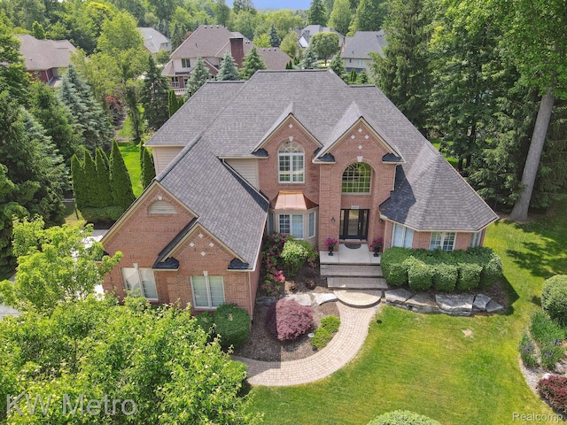 14163 Longneedle Ct, Shelby Twp, MI 48315 - traditional-style house featuring brick siding, a shingled roof, and a front lawn