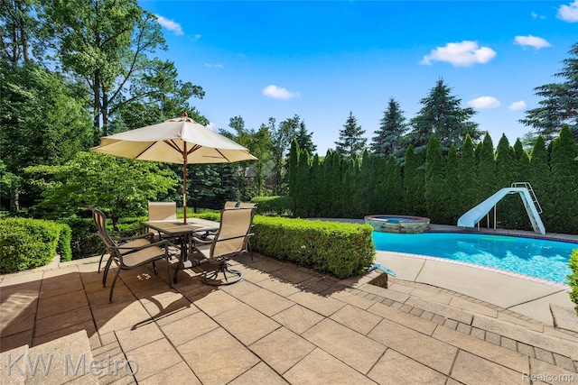 14163 Longneedle Ct, Shelby Twp, MI 48315 - view of pool featuring a water slide, a patio area, outdoor dining space, and a pool with connected hot tub
