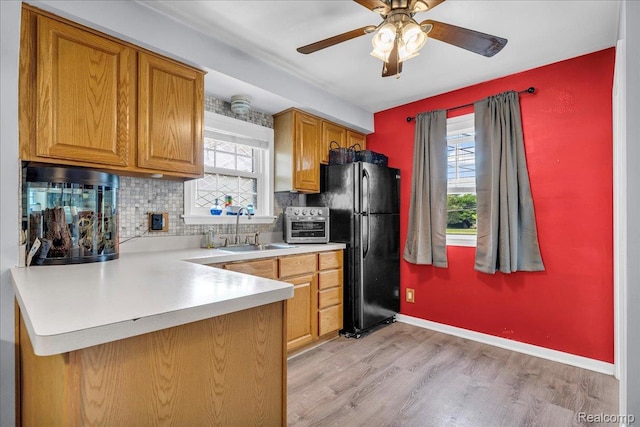 3220 John R St, Trenton, MI 48183 - kitchen featuring a sink, freestanding refrigerator, decorative backsplash, ceiling fan, and light wood-style flooring